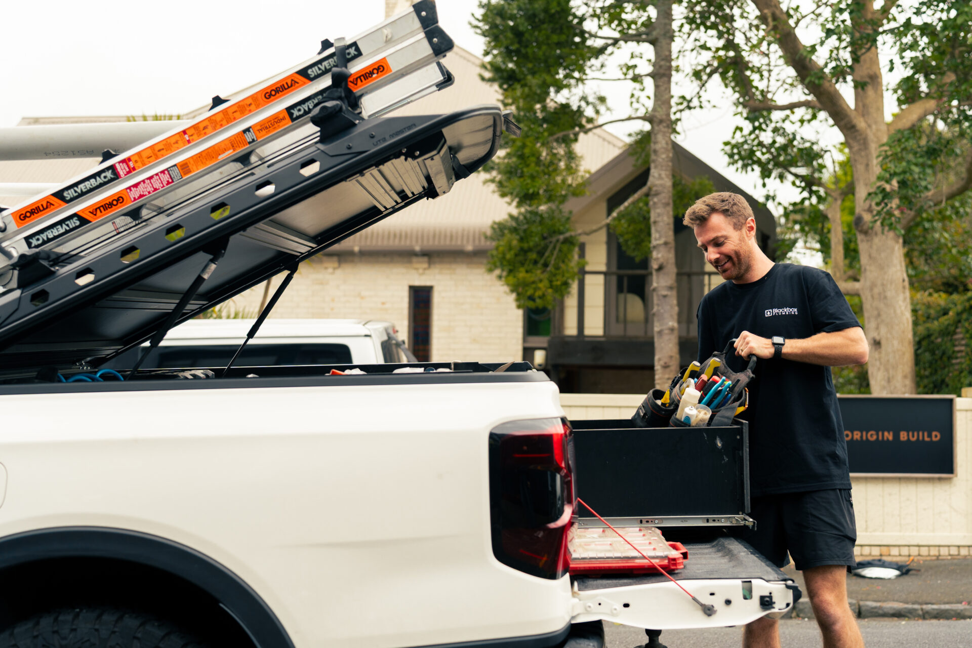 A Blackbox Plumbing technician loading tools from the work van